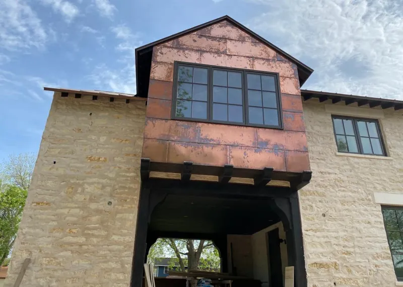 Copper metal panel facade on a stone building for Skylight Installation in Payette